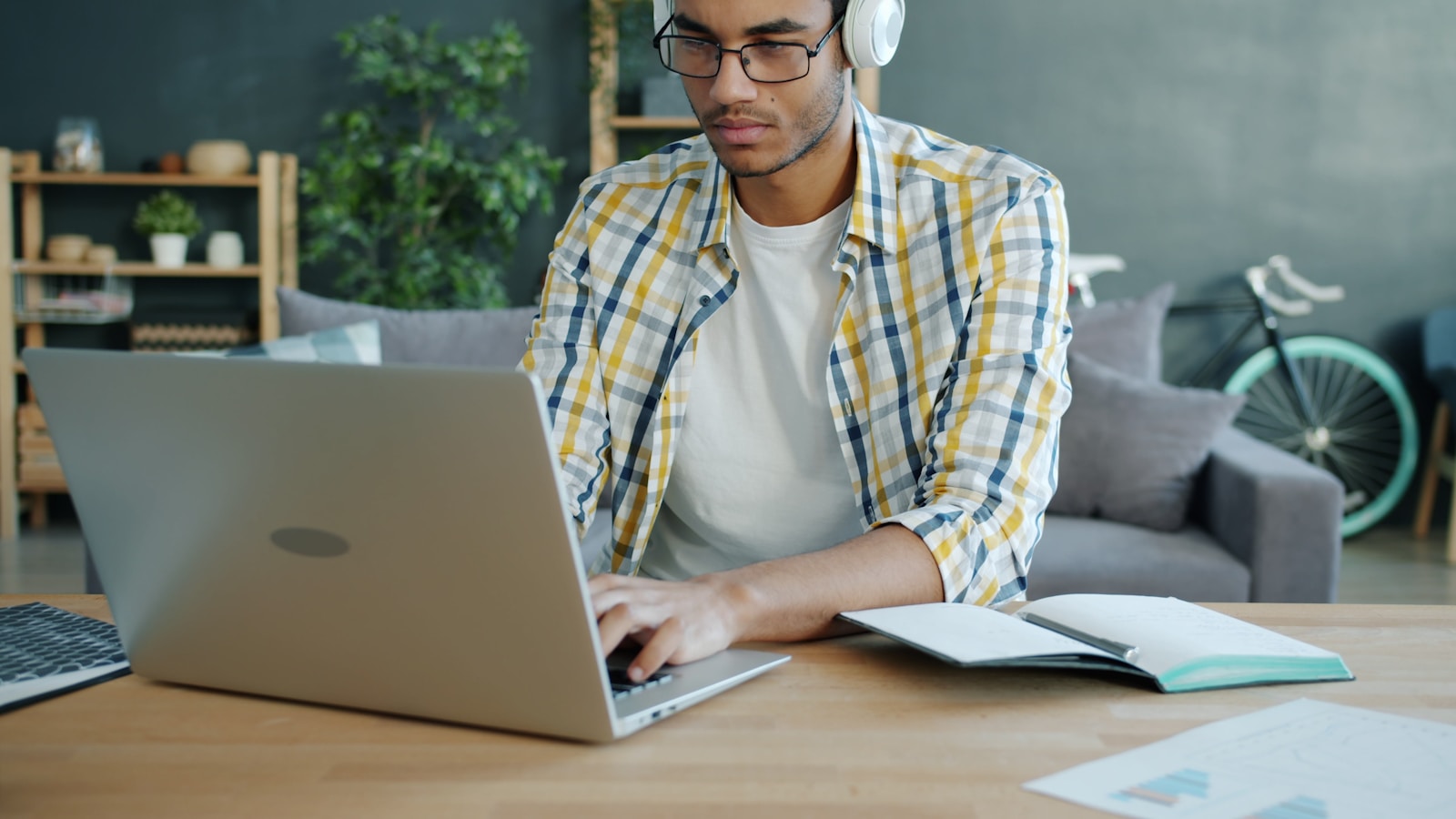 Man wearing headphones working on a laptop at a desk