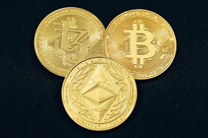 three gold bitcoins on a black background