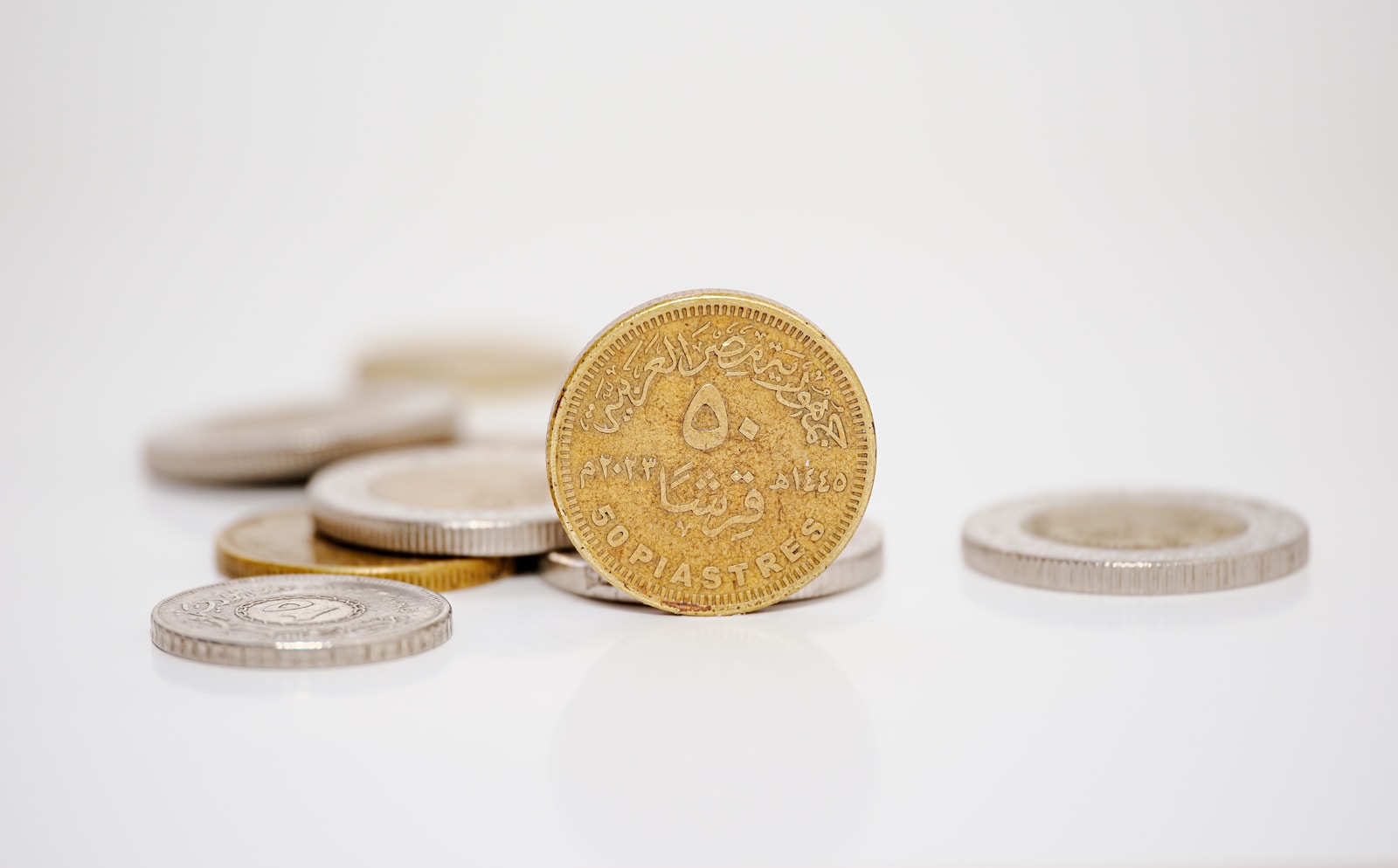 A pile of coins sitting on top of a white table